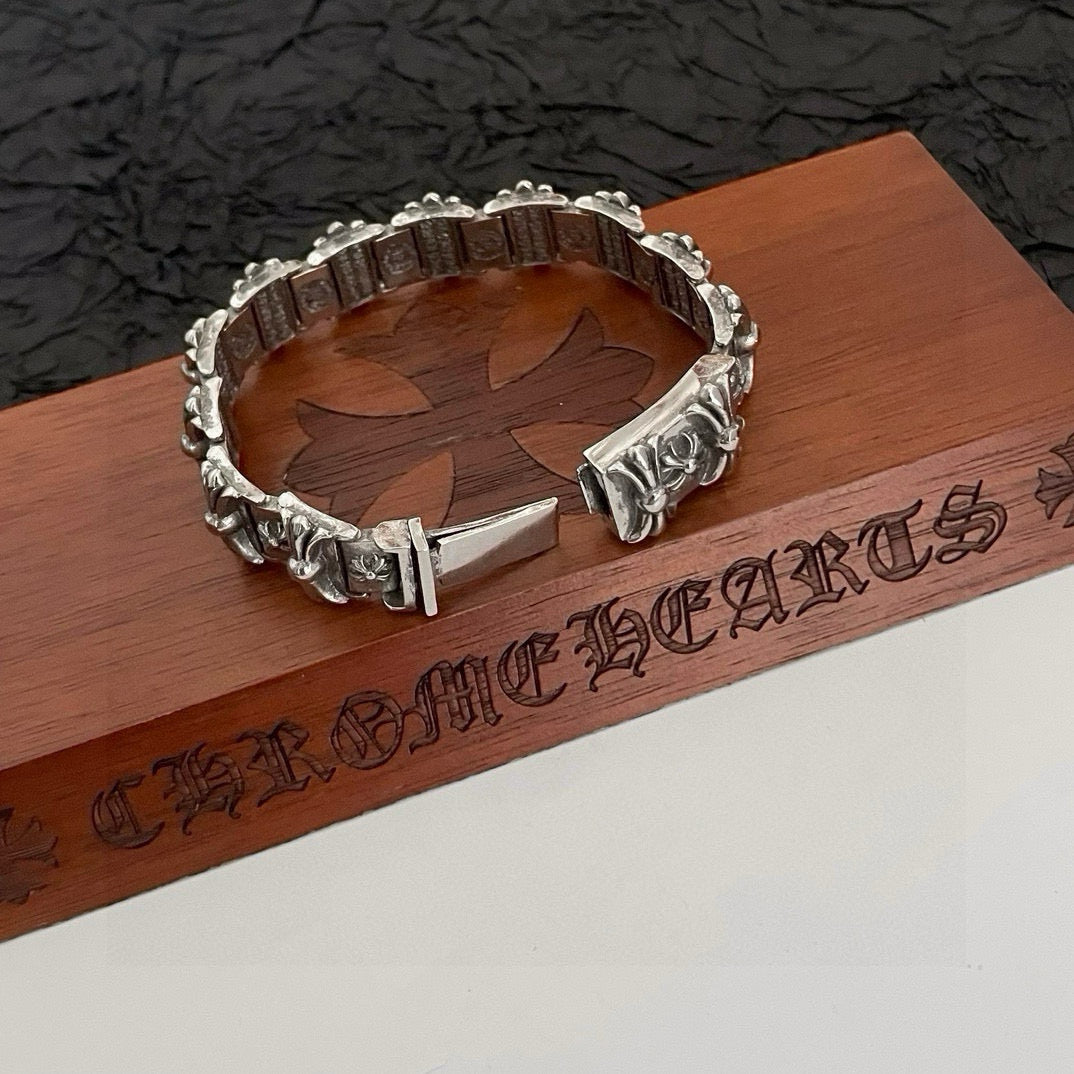 Silver-tone engraved bracelet with floral corner details and a pointed bar clasp