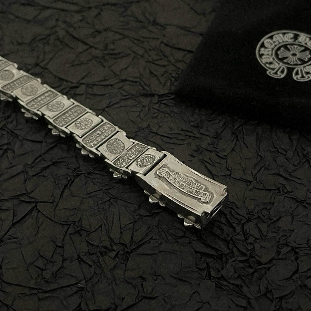 Silver-tone bracelet with rectangular engraved links and an extended clasp plate