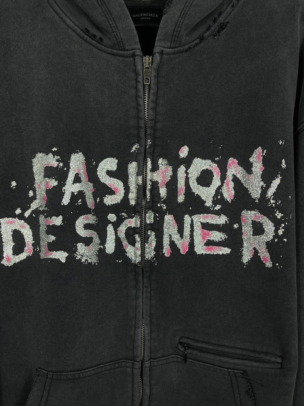 Balenciaga dark zip hoodie close-up: 'Fashion Designer' graphic and front zipper