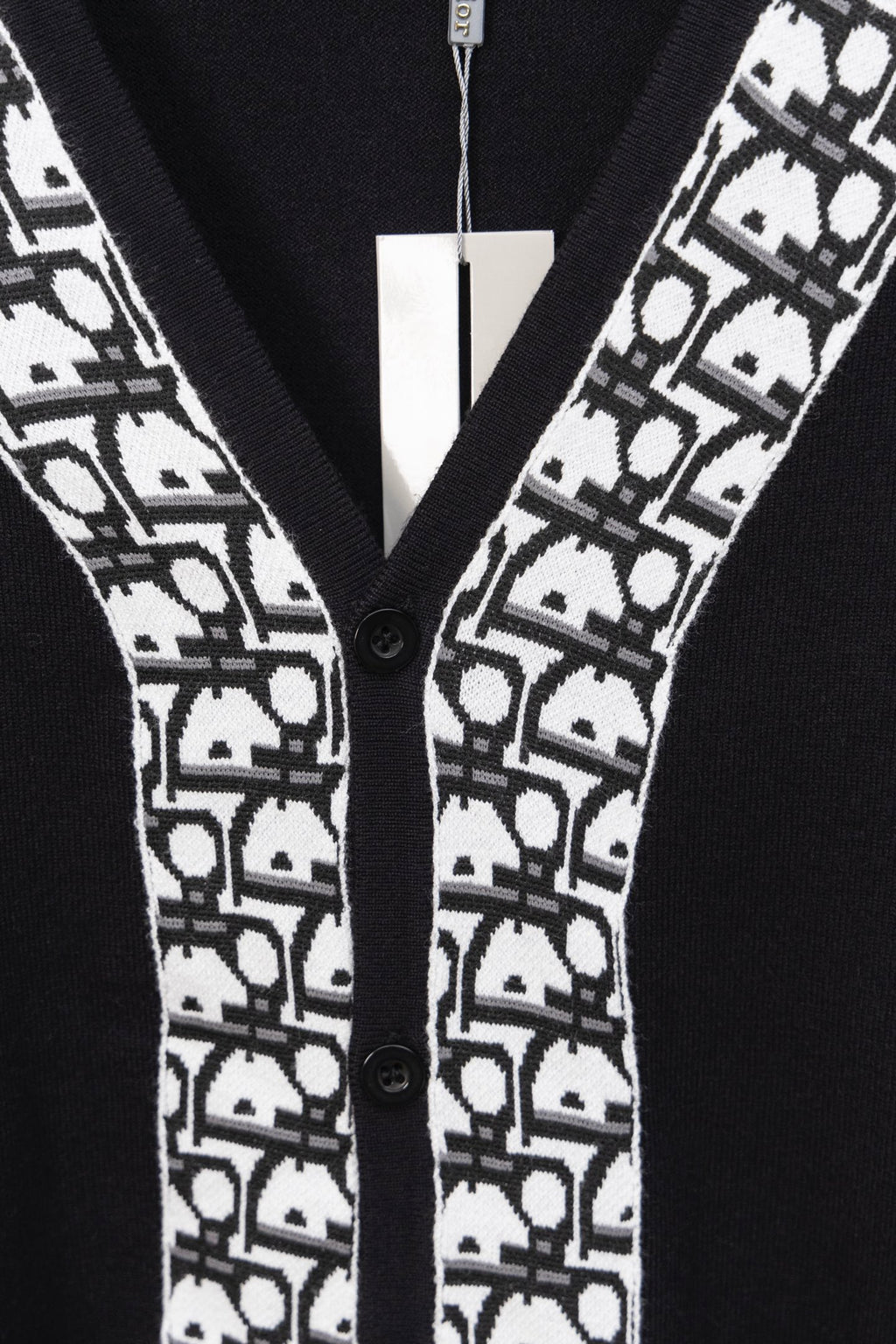 Black cardigan front with white patterned trim and black buttons