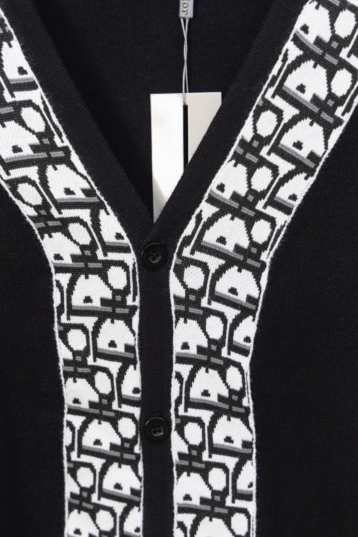Black cardigan front with white patterned trim and black buttons