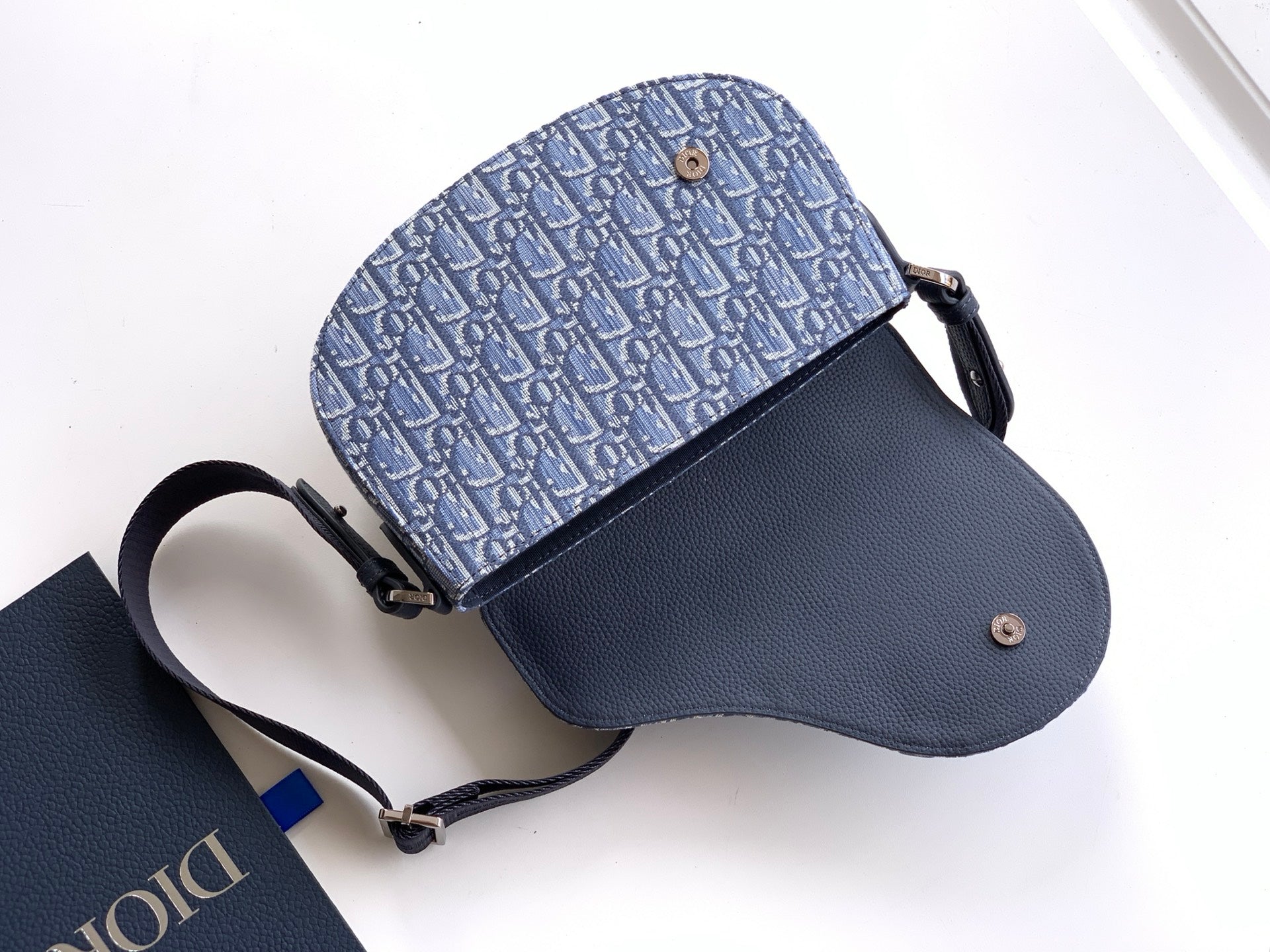 Dior crossbody bag with blue monogram body and navy leather base, detachable strap