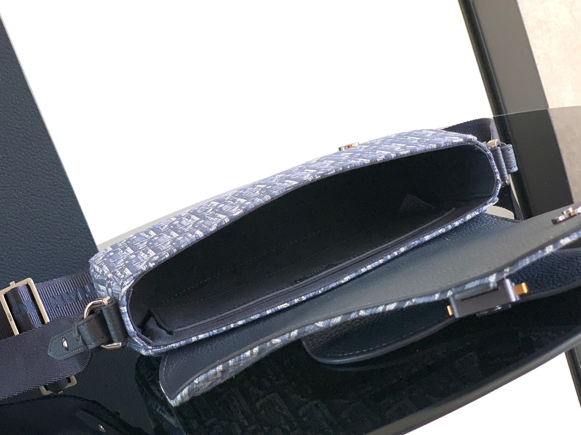 Dior men's crossbody bag open top showing inner lining and leather trim