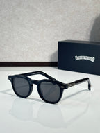Black round sunglasses with dark lenses and textured temple detailing