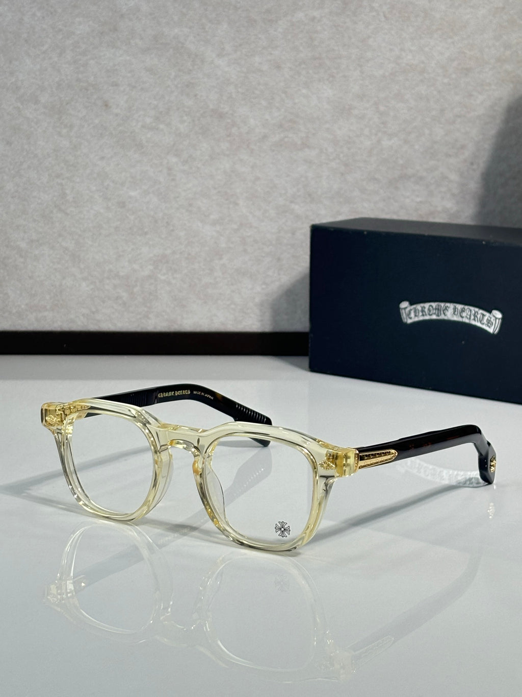 Clear gold-tone round eyeglasses with transparent lenses and metal temples