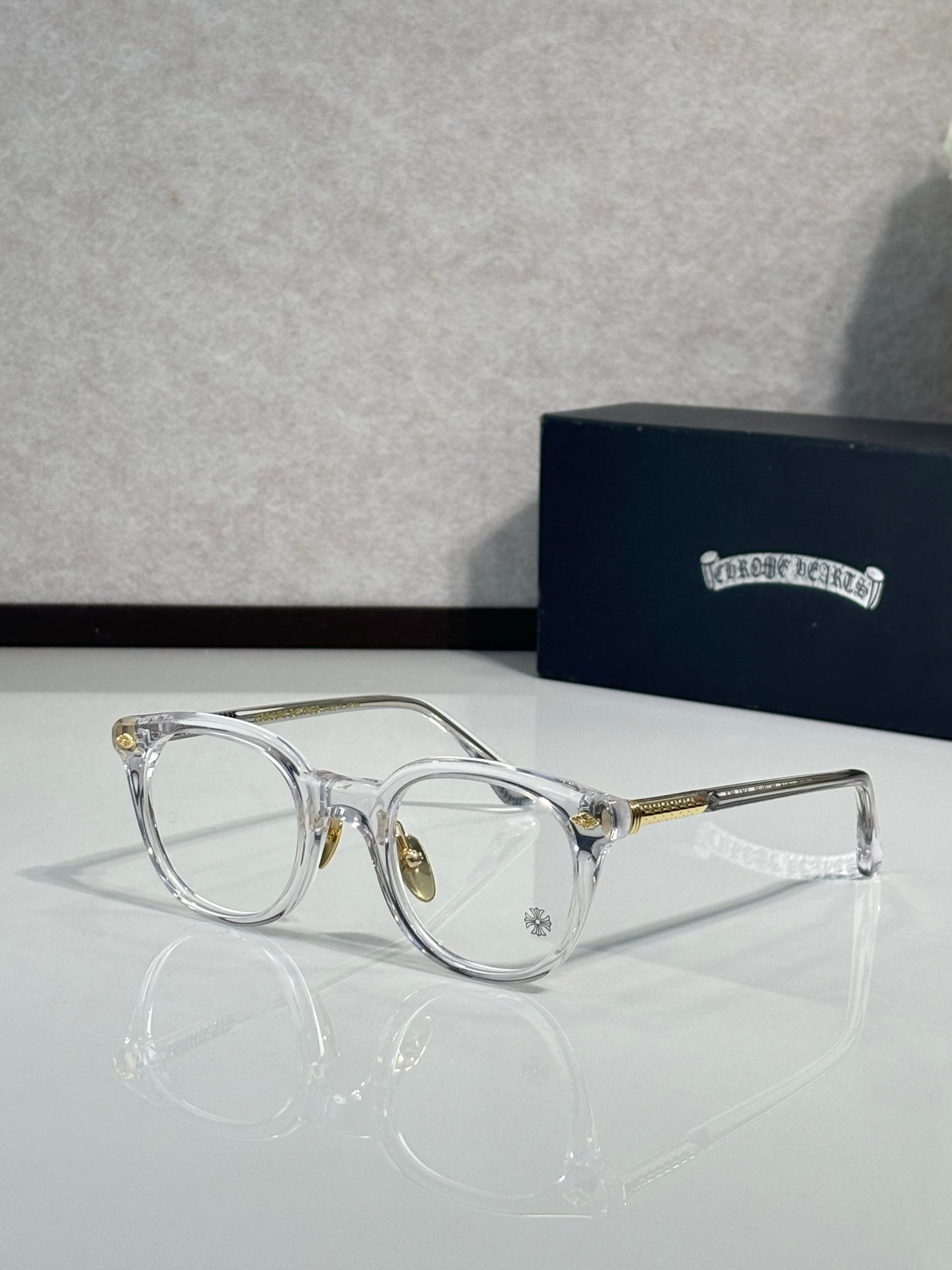 Silver round eyeglass frames with tinted lenses and gold-tone temples
