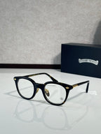 Black round eyeglass frames with clear lenses and gold-tone temples