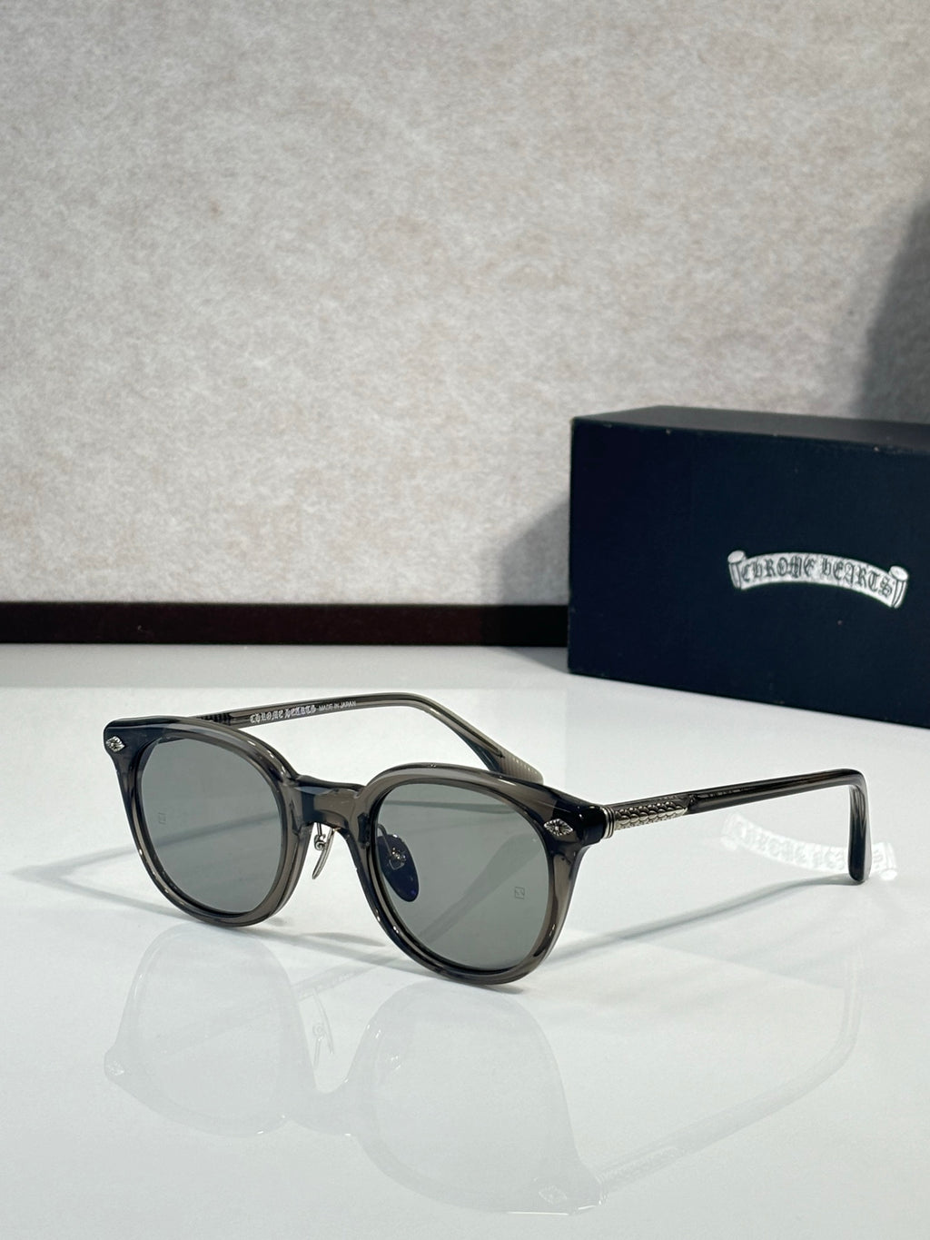 Black round eyeglass frames with clear lenses and gold-tone temples