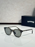Black round eyeglass frames with clear lenses and gold-tone temples