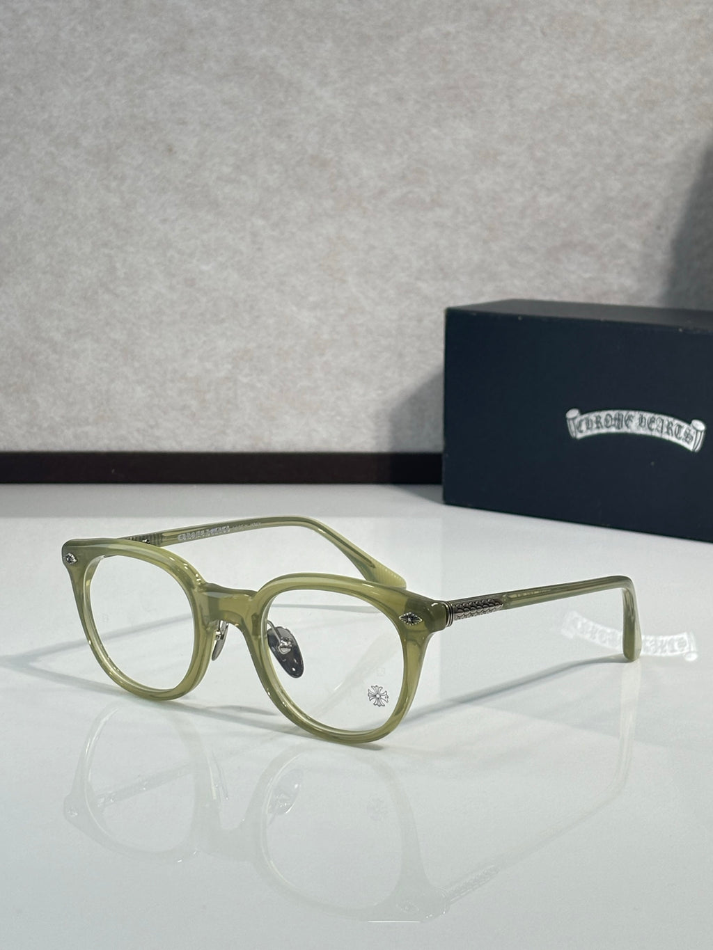Olive green round eyeglasses with clear lenses and gold-tone arms