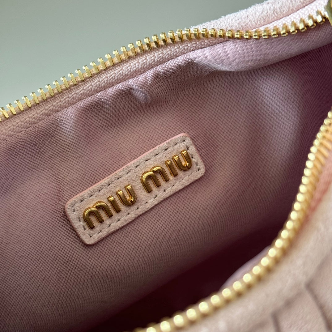 Pink fabric lining with “miu miu” label and gold zipper track