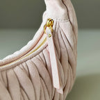 Light pink matelasse mini handbag with gold zipper pull and side ring