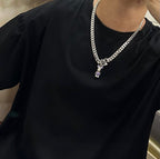 Louis Vuitton silver chain necklace on black shirt, green V and purple charm