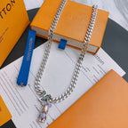 Louis Vuitton silver chain necklace with bear charm pendant and purple accents on card