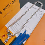Louis Vuitton silver chain necklace with green V pendant and bear charm, on cards
