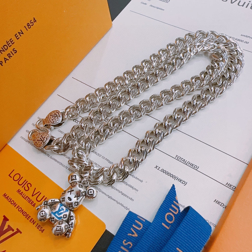 Louis Vuitton silver chain necklace with multiple charm pendants, on display