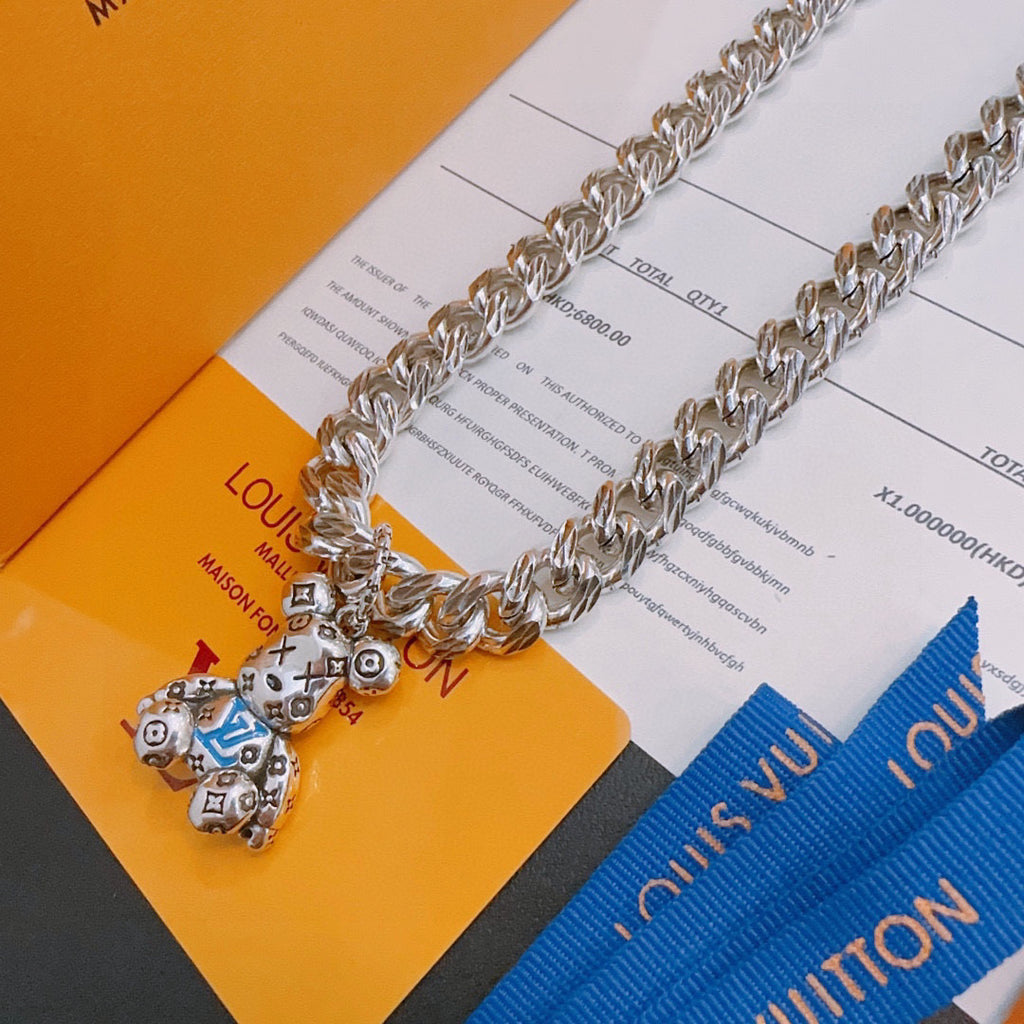 Louis Vuitton silver chain necklace with charm pendant and blue tag, flat lay