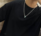 Silver-tone chain necklace worn with small green pendant