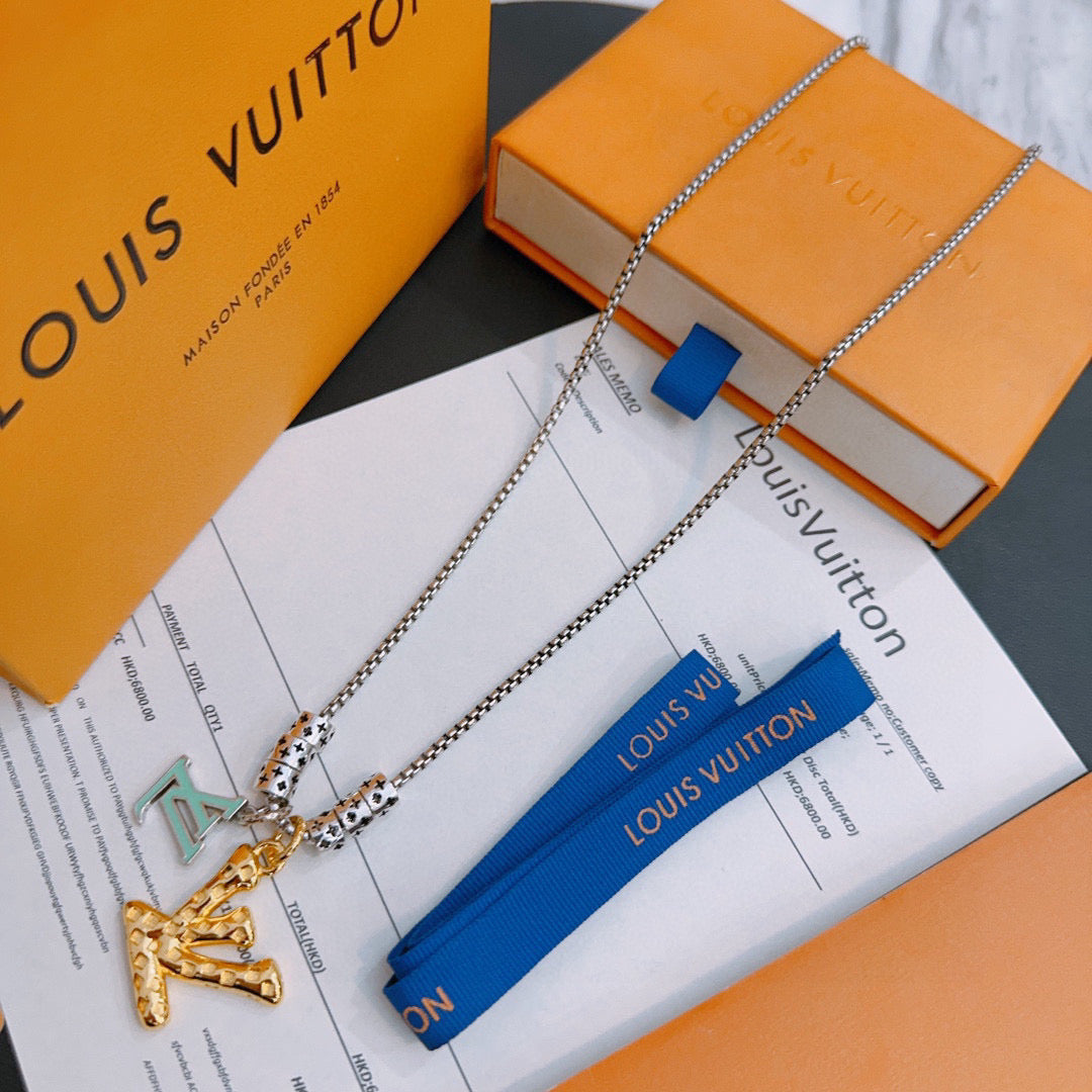 Louis Vuitton necklace with silver chain, gold pendant, and blue ribbon tag, on box
