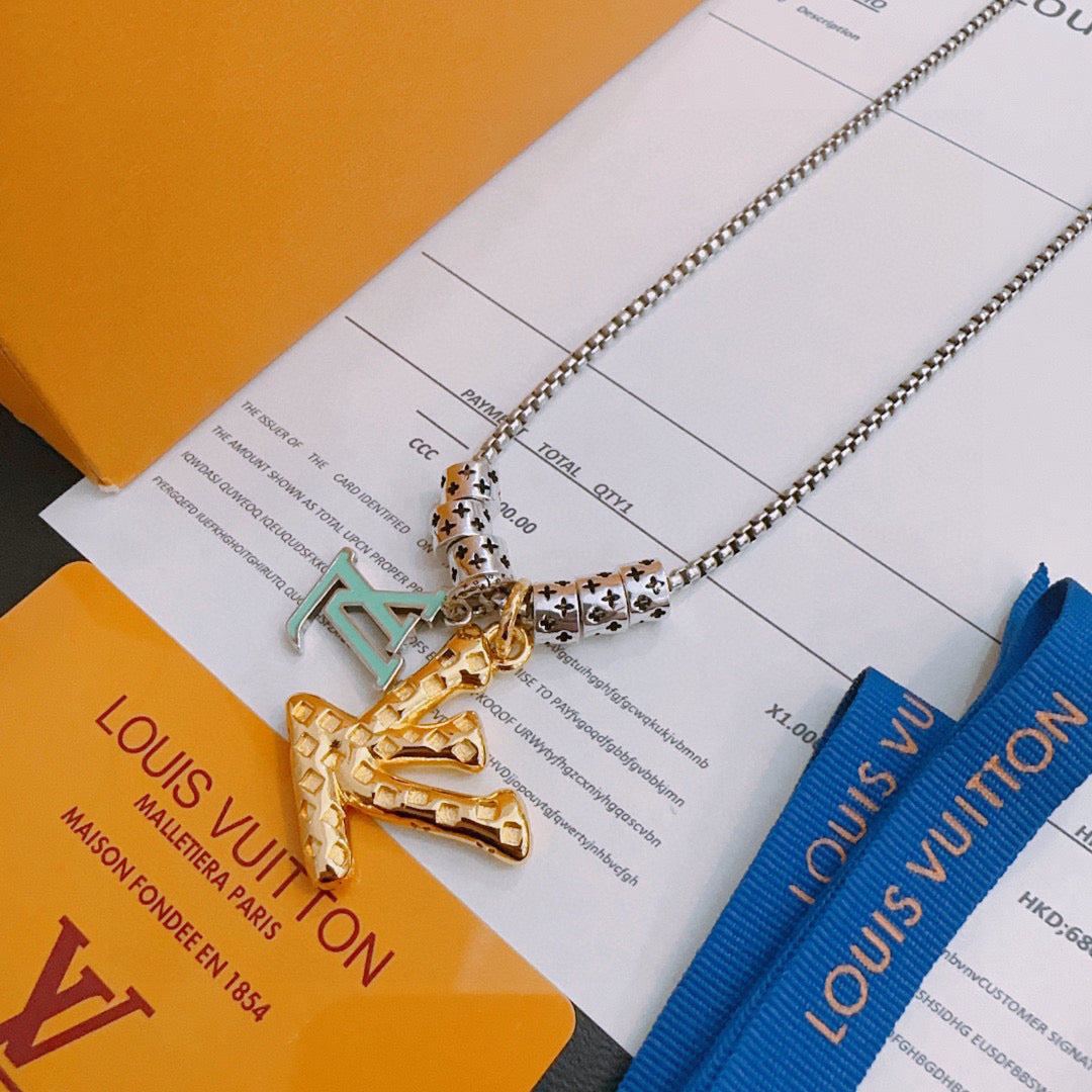 Louis Vuitton necklace with silver chain and gold star-like pendant, on accessory card