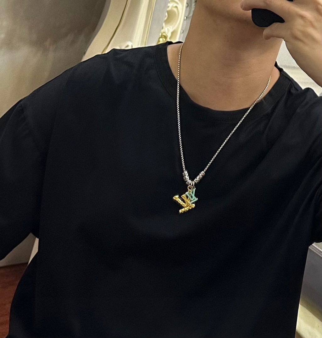 Louis Vuitton necklace worn: silver chain with gold LV star pendant on black top