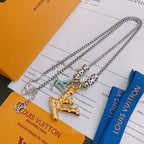 Louis Vuitton necklace with silver chain and gold pendant charms, on accessory card