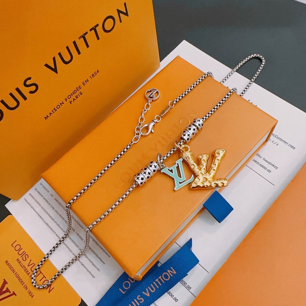 Louis Vuitton necklace with silver chain and gold crown pendant, on orange gift box