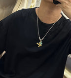 Louis Vuitton necklace worn: delicate silver chain with gold LV star pendant