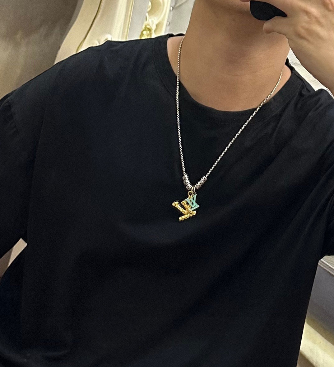 Louis Vuitton necklace worn: delicate silver chain with gold LV star pendant