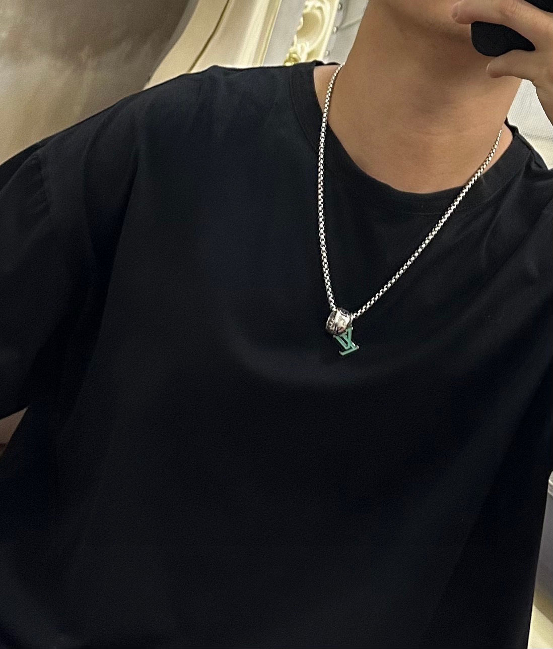 Silver-tone chain necklace with multicolor square charm pendant, worn on a black top.