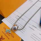 Silver-tone chain necklace with multicolor square charm pendant, close-up on cards.