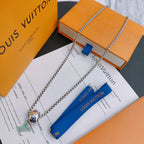 Silver-tone chain necklace with multicolor charm pendant, layered on cards.