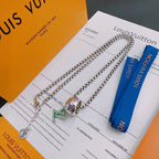 Silver-tone chain necklace with multicolor charm pendants and blue ribbon on cards.
