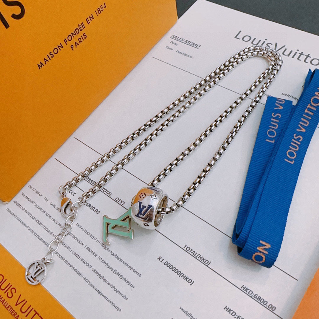 Silver-tone chain necklace set with square charm pendants and blue ribbon.