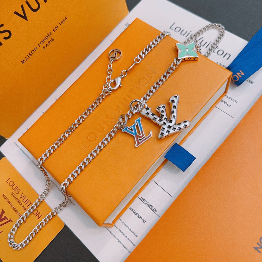 Silver-tone chain necklace set with green star charm and geometric multicolor pendant