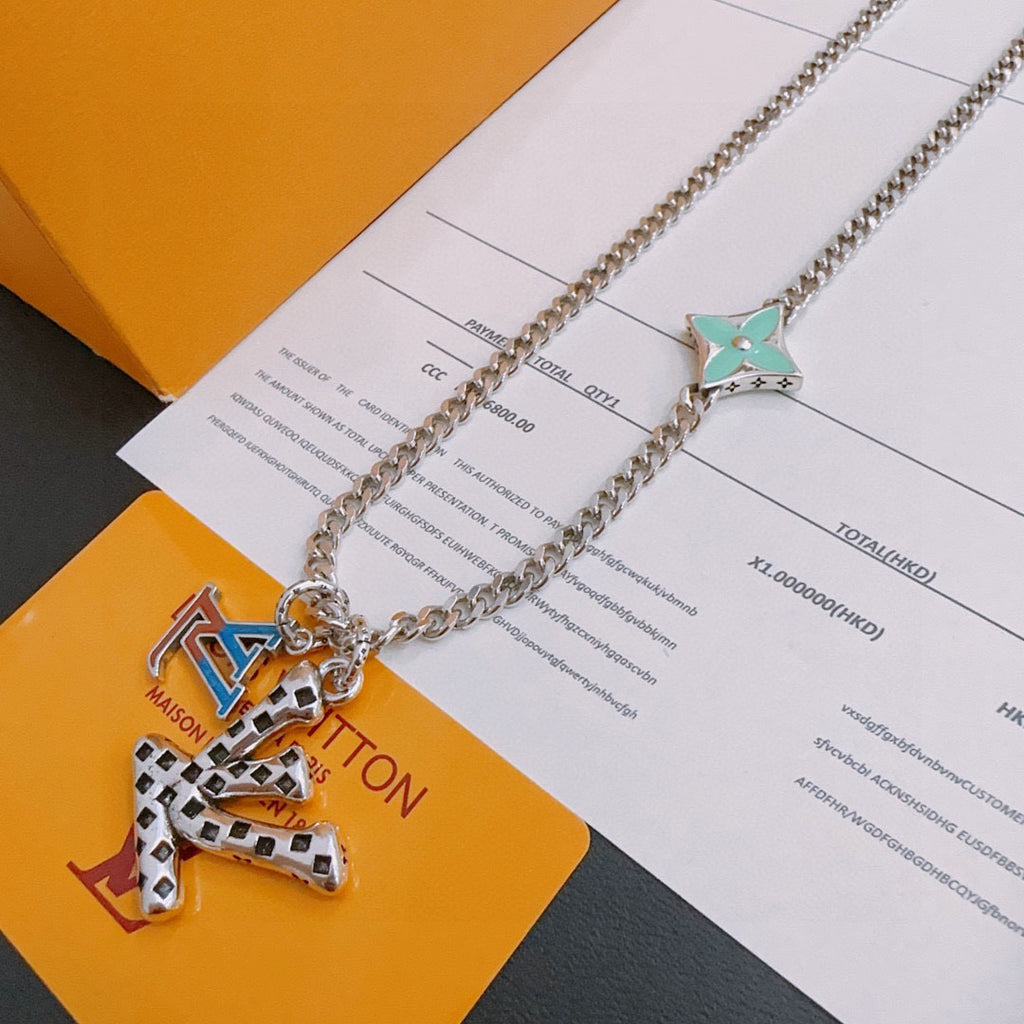 Silver-tone chain necklace with green star charm and multicolor letter pendant