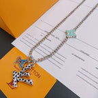 Silver-tone chain necklace with green star charm and multicolor letter pendant