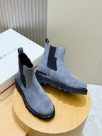 Moncler suede Chelsea boots with elastic side panels and dark rubber soles, on display