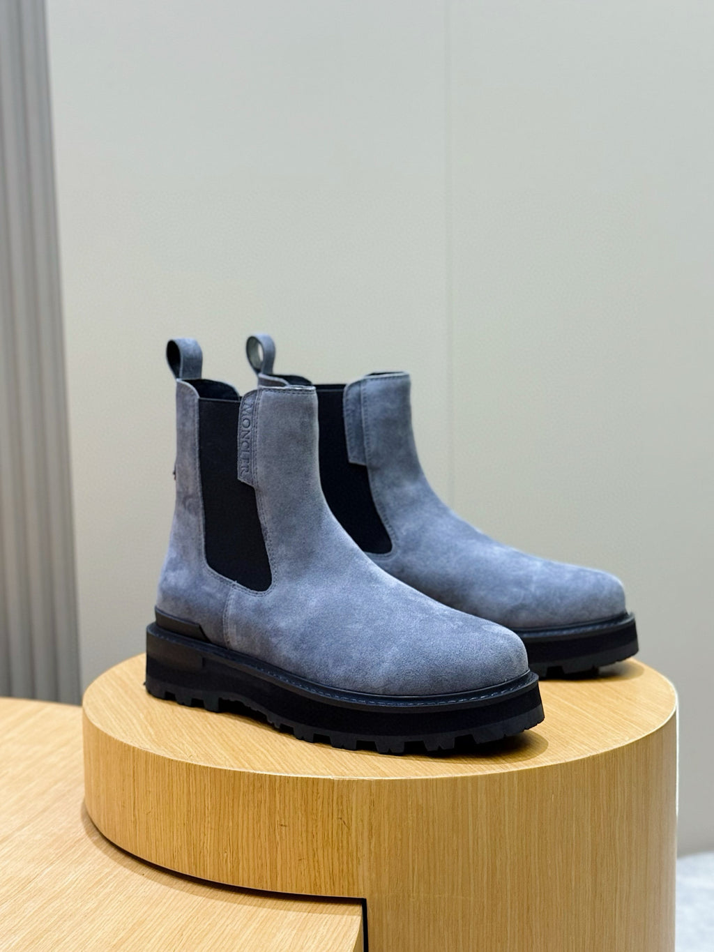 Moncler suede Chelsea boots with elastic side panels and chunky dark rubber sole, angled