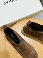 Moncler brown suede slip-on Chelsea boots with black interior, on wooden stand