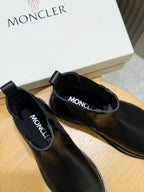 Black Chelsea boots with Moncler logo on insole lining and elastic side panels