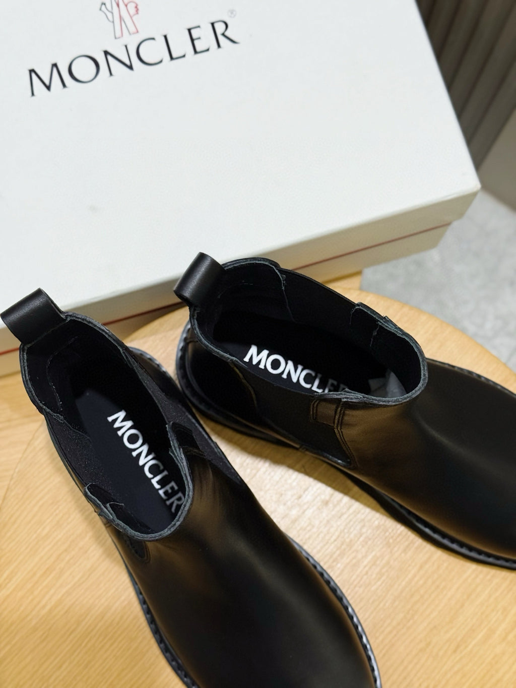 Black Chelsea boots with MONCLER logo on the insole and side elastic panels