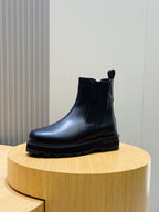 Black Chelsea boot with elastic side gore and thick treaded sole, ankle height