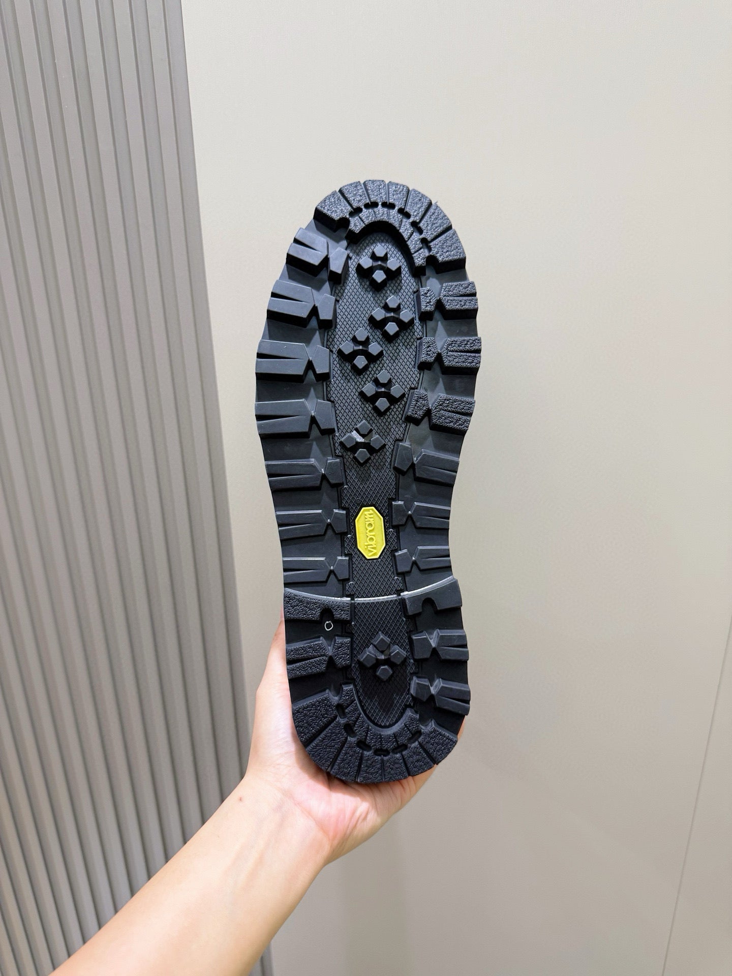 Chelsea boot outsole view with deep tread and small yellow accent