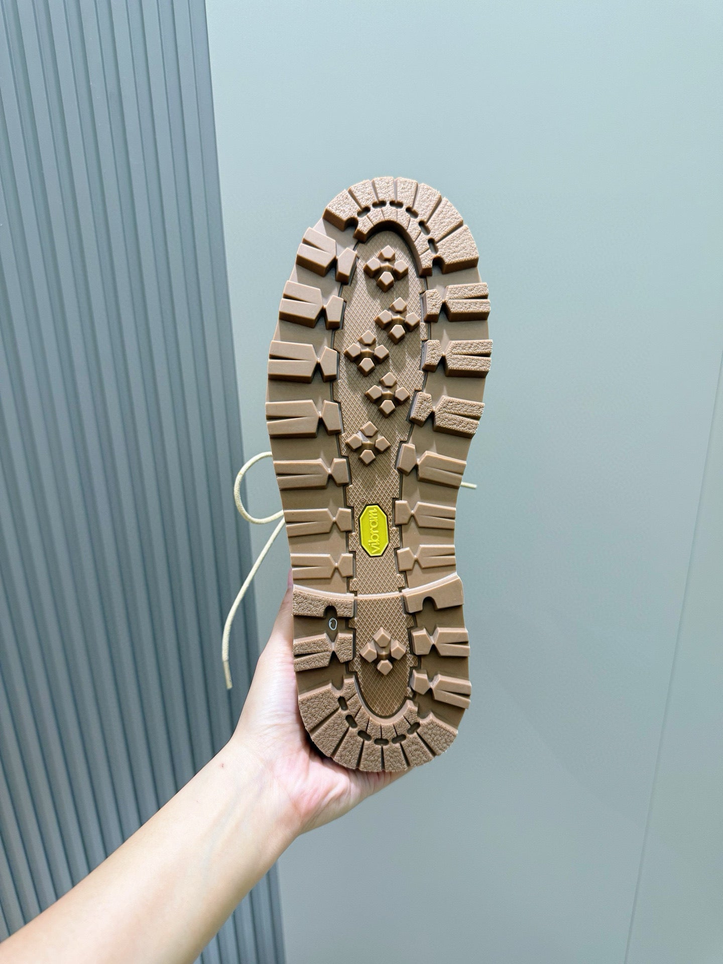 Boot outsole tread with beige rubber traction and yellow accent patch