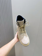 Light beige suede ankle boot with lace-up closure and dark blue collar