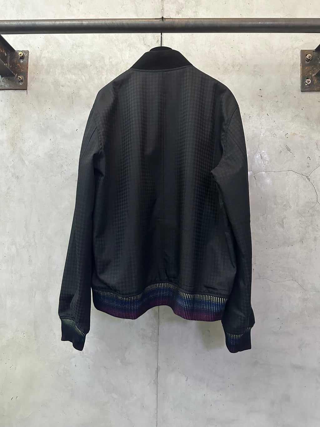 Long-sleeve jacket back view, dark fabric with multicolor striped ribbed hem