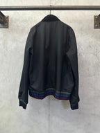 Long-sleeve jacket back view, dark fabric with multicolor striped ribbed hem