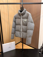 Moncler long quilted puffer jacket in light gray, standing front view with logo patch