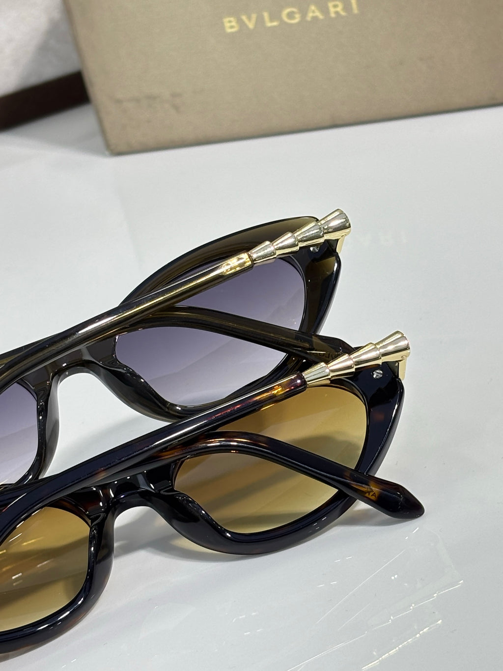 Black sunglasses close-up with gold-tone temple tips and tinted lenses